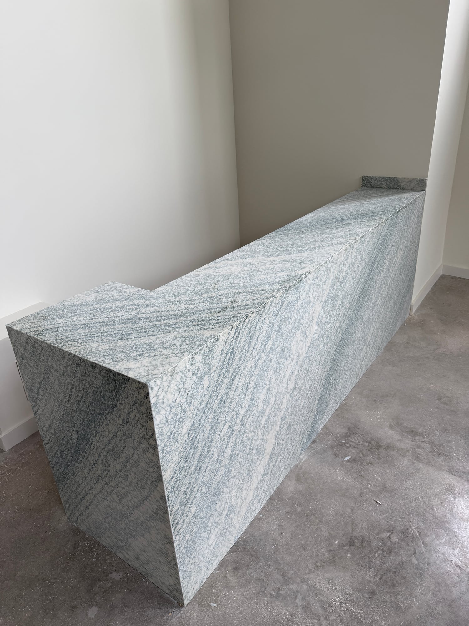 Long custom stone counter with a fully clad front during installation