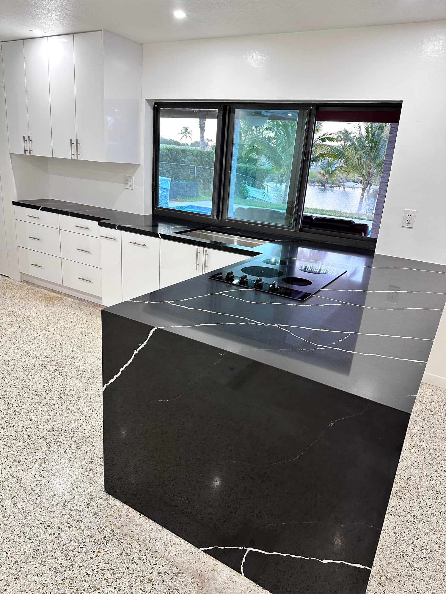 Black waterfall kitchen countertop with fine white veining