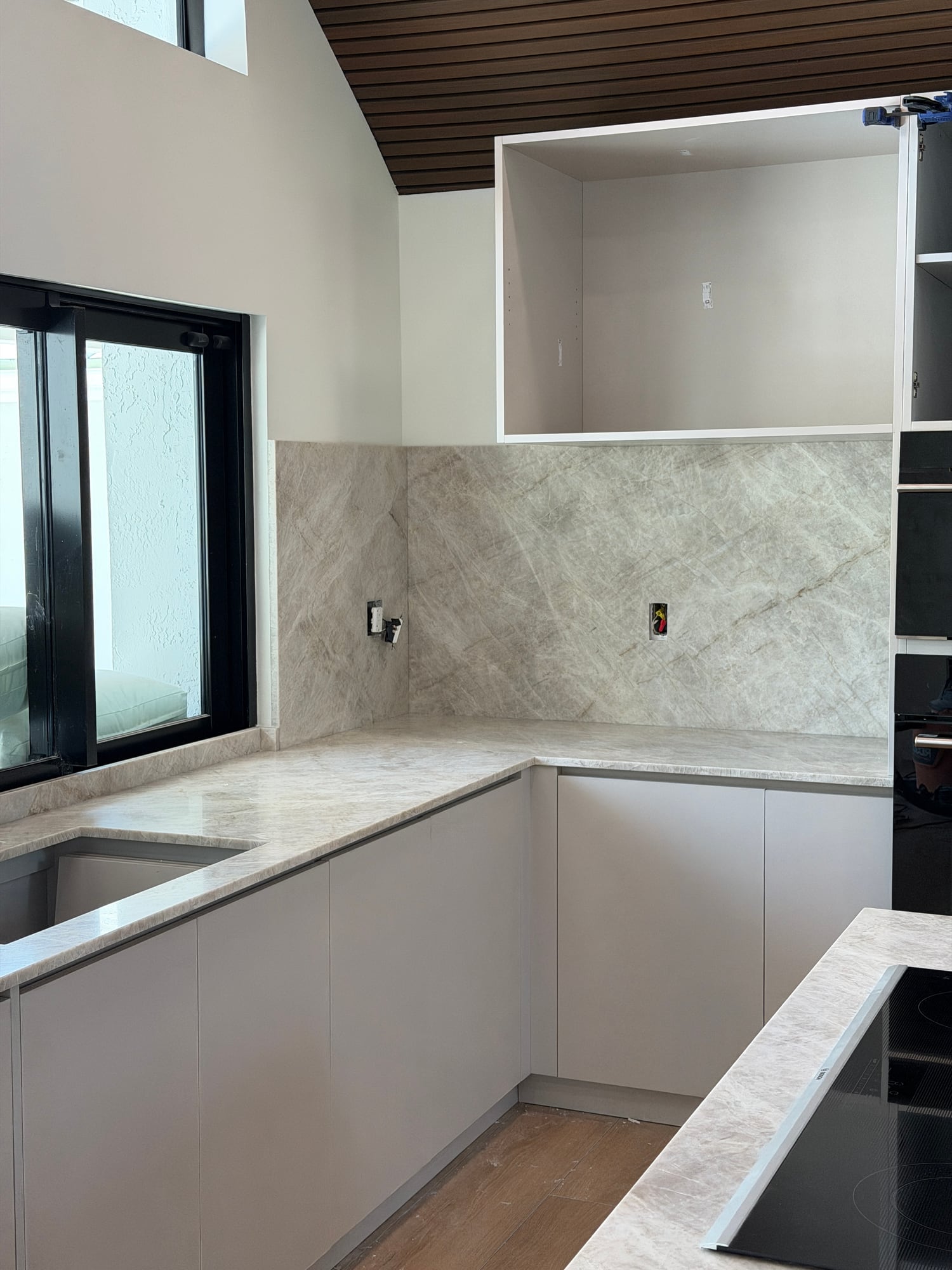 Full-height kitchen backsplash and countertop during installation